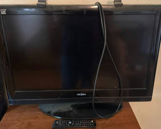 Lot 108: Insignia flat-screen TV with built-in DVD player on wooden dresser