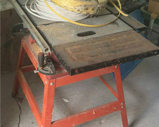 Lot 203: SkilSaw table saw on red work stand with coiled cables