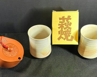 Lot 17: Yixing-style brown teapot with two cups and yellow box