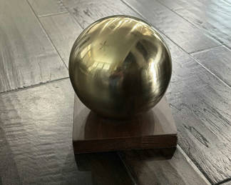 Lot 85: Gold metal sphere on wooden pedestal