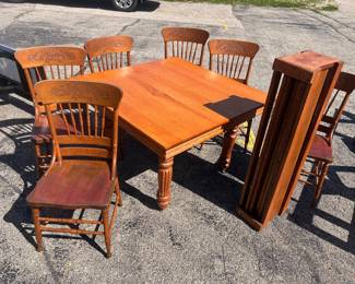 A beautiful oak table with  5 leaves and 6 pressback and spindal chairs.