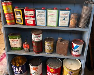 Top shelf - tobacco related tins, 2nd shelf - gun powder tins, bottom two shelves - automotive tins.