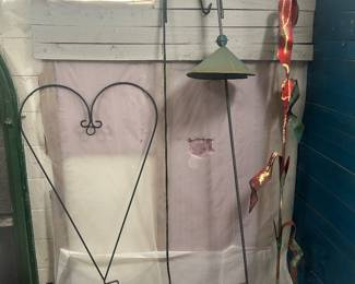 Various shepherds hooks w/ a tall corn stock on the right side.