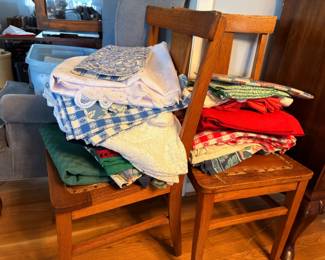 Antique oak chair with folded linens and tablecloths