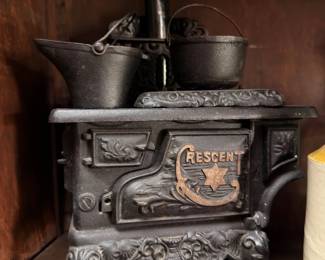 Antique Crescent cast iron toy stove with miniature pots