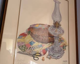 Framed signed still life print, oil lamp and quilt