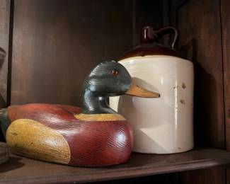 Carved wood duck decoy and antique stoneware jug