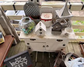 White painted dresser with garden decor, birdhouses and planters