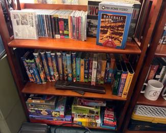 Shelf of DVDs, VHS tapes, books and board games