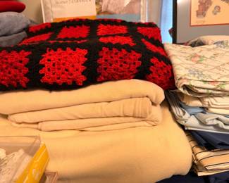 Linens, crocheted granny square afghan, blankets and folded textiles