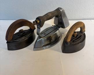 an Montgomery Wand Quick Lightning Gas Powered Iron with Two Cast Iron Sad Irons