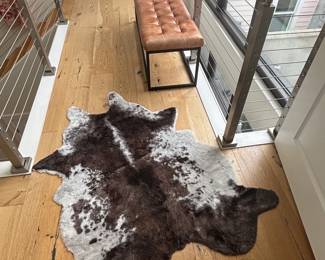 Cowhide rug and Jofran Global Archive leather tufted bench