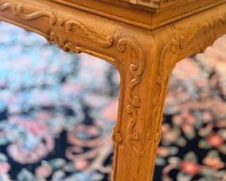 Carved wood table leg on Oriental rug