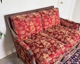 Carved wood settee with red upholstery