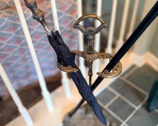 Umbrellas and cane in metal stand