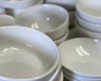 Stacks of white dishes and bowls