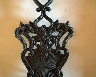 Vintage Cast Iron Trivet heart-shaped handle and a starburst pattern in the center
