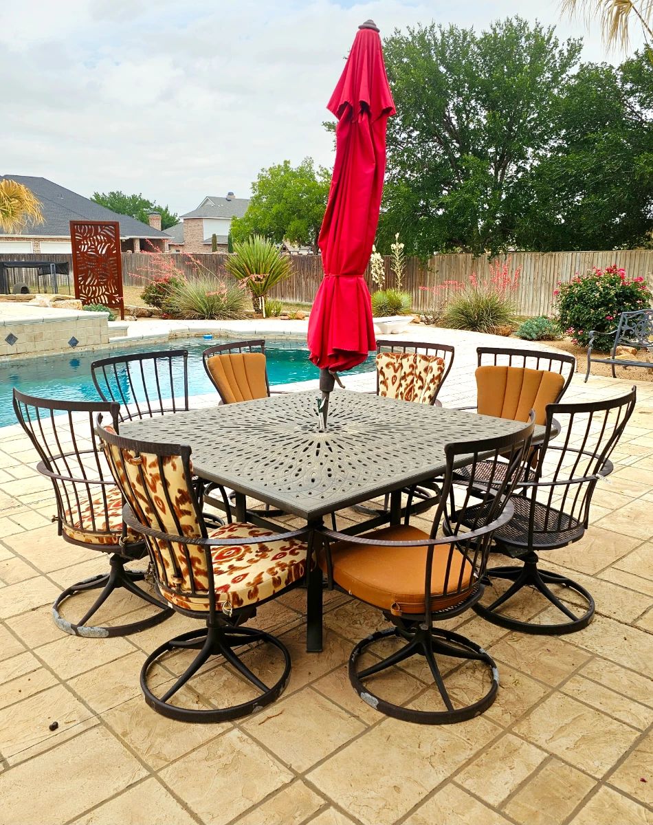 Ow Lee metal patio set includes eight swivel chairs and table. Please note the paint is flaking on the powder coat on the chairs but otherwise in good condition. Not all chairs have cushions. Umbrella sold separately