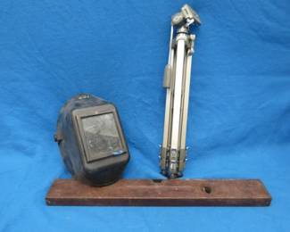 Lot 132. Wooden Stanley level with both vials intact, tripod, and a welding helmet
