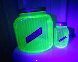 Lot 197. Eight green Depression ribbed uranium glass canisters and spice jars. All items glow under a UV light.