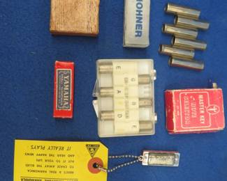 Lot 44. Two guitar pitch pipes and more: Two guitar pitch pipes. Three empty tuner/pitchpipe boxes. "Lucky Miniature" three-hole novelty harmonica marked "Medal". Master Key Note Selector and box.