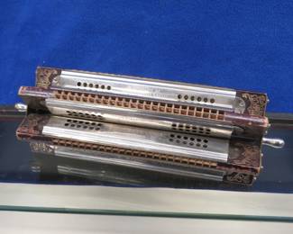 Lot 25. Hohner Sextet tremolo paddle wheel rotary harmonica in the keys of A, D, G, C. F, and B. Minimum bid $100. Each harmonica has 48 holes and sounds great. Wooden and glass display cabinet included.