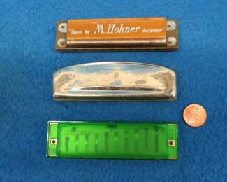 Lot 161. Three harmonicas: Hohner 10-hole diatonic harmonica. Sounds great. Hohner 10-hole diatonic plastic harmonica. Sounds great. Unknown maker "My Home is My Castle" diatonic harmonica with poor sound