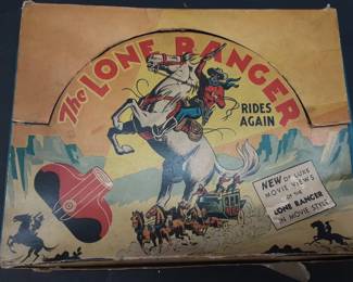 Vtg. Lone Ranger Movie Viewer The Lone Ranger Rides again. Includes multiple movie reels, viewer with internal movement wheel for film. Outer knob to turn reels has deteriorated