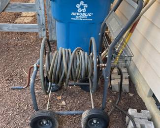 T133 - $30. Hose reel on metal rolling cart. Needs air in the tires. 