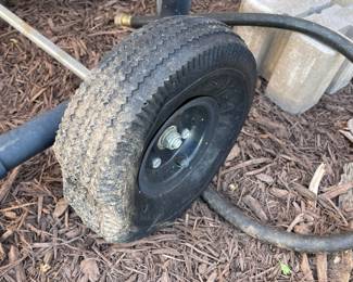 T133 - $30. Hose reel on metal rolling cart. Needs air in the tires. 