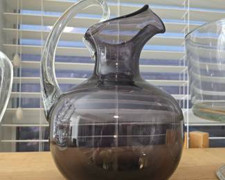 Hand-blown smoky amethyst pitcher with clear glass handle.  Believed to be Blenko. 