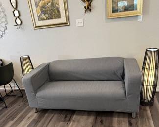 pair of eye-catching lamps, sofa and lots of wall art