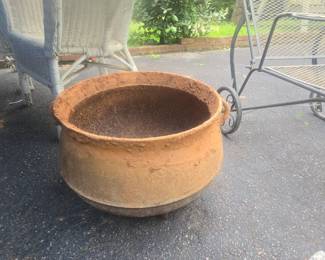Large concrete cast iron cauldron freshly dug out of the grass