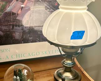 saks 5th Ave Snow globe of Chicago skyline $30; 18”h Hurricane brass table lamp with frosted pie crust scalloped shade $30