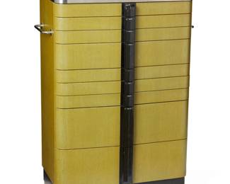 374 An American Cabinet Co. Art Deco style dental cabinet Mid-20th century Metal tag to the verso: The American Cabinet Co. / Made in the U.S.A. The streamlined nine-drawer cabinet with chartreuse green painted wood body, black plastic drawer pulls and top, and brushed steel banding accents flanking the top and base; steel handles to either side of the body and mechanized, button-release upper storage compartment 45" H x 27.5" W x 15.5" D Estimate: $400 - $600