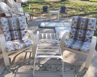 Several sets of patio side tables, chairs and cushions