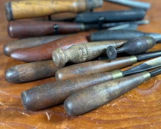 Vintage woodworking tools, including chisels and gouges with wooden handles. Some tools are marked “Buck Bros, ” known for quality craftsmanship. Handles exhibit wear consistent with age and use. The lot includes a variety of sizes and types for woodworking projects or collection purposes. Condition varies, with some minor rust and patina on metal components.
