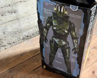 Halo Supreme Edition Master Chief costume, featuring detailed armor components and bodysuit. Includes helmet, chest piece, and other parts. Comes in its original packaging, which shows signs of wear, including creases and tears. Appears to be used and is sold as is. Ideal for collectors or cosplay enthusiasts.