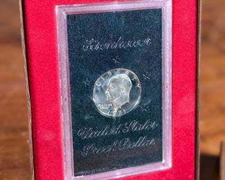 This lot features a 1971 United States Mint Eisenhower “Brown Box” Proof Dollar, which is a collectible numismatic coin. The coin is struck in a 40% silver composition.