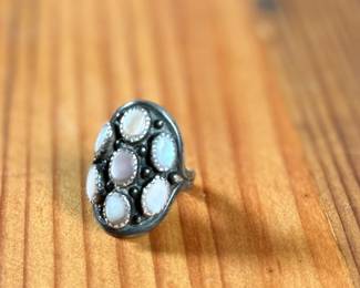This lot features a beautiful sterling silver ring with what appears to have mother of pearl inlay. Signed, “touchine” and comes in a size 7.