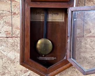This lot features a Seth Thomas “World” model long-drop schoolhouse clock from the late 19th century.  It features a distinctive octagonal top and a long lower case for the pendulum. Tested and in good working condition with key. Measures, 32” H x 17” W.