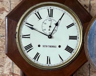 This lot features a Seth Thomas “World” model long-drop schoolhouse clock from the late 19th century.  It features a distinctive octagonal top and a long lower case for the pendulum. Tested and in good working condition with key. Measures, 32” H x 17” W.