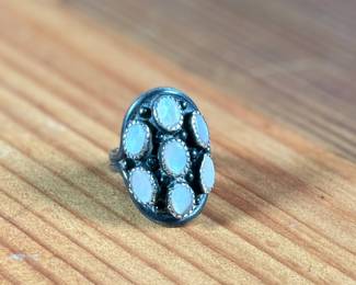 This lot features a beautiful sterling silver ring with what appears to have mother of pearl inlay. Signed, “touchine” and comes in a size 7.