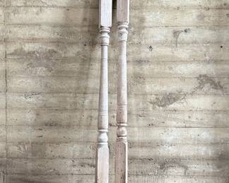 Distressed wooden architectural columns, featuring turned designs and a weathered finish indicative of their age. Each column has a square base transitioning to a detailed, rounded profile. Each measures, 96” H x 4.5” W x 4.5” D.