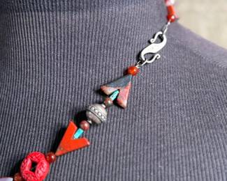 This lot features a beautiful necklace with sterling silver and what appears to be carved coral and turquoise. This necklace is in excellent condition and measures, 22”.