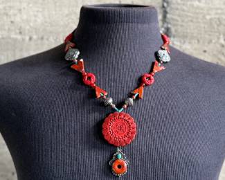This lot features a beautiful necklace with sterling silver and what appears to be carved coral and turquoise. This necklace is in excellent condition and measures, 22”.
