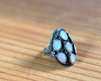 This lot features a beautiful sterling silver ring with what appears to have mother of pearl inlay. Signed, “touchine” and comes in a size 7.