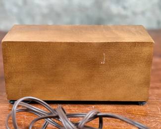 Seth Thomas vintage wooden flip clock featuring a natural woodgrain exterior with a silver-tone faceplate. Displays time using a rotating flip mechanism. Includes an attached electric cord for operation. Minimal signs of wear are visible consistent with age. Tested and in working condition.