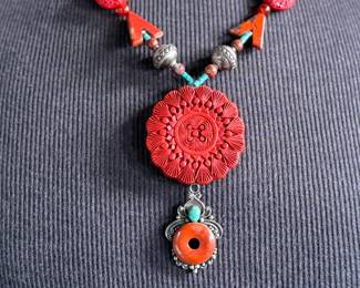 This lot features a beautiful necklace with sterling silver and what appears to be carved coral and turquoise. This necklace is in excellent condition and measures, 22”.