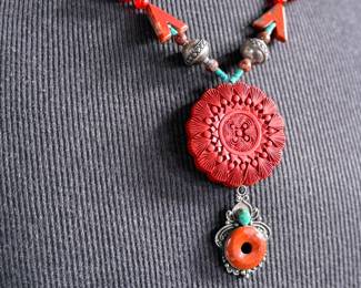 This lot features a beautiful necklace with sterling silver and what appears to be carved coral and turquoise. This necklace is in excellent condition and measures, 22”.